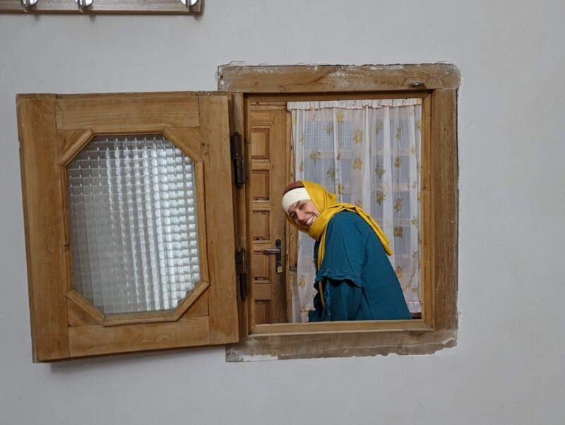 Saeideh through the odd mysterious little window in the wall in village home for rent in Lāsem, population 44, Dashte Gole-Zard area, a refuge from the madness of Tehran, Iran. Copyright Ali Torkzadeh, EscapefromTehran.com