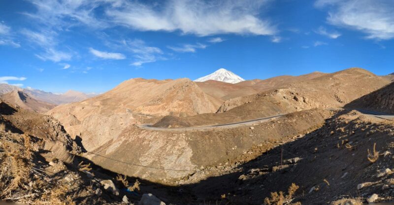 Mt. Damāvand peaking over the horizon, like a white arrow striking the blue sky, in Dashte Gole-Zard area, two hours northeast of Tehran, Iran. Copyright Ali Torkzadeh, EscapefromTehran.com