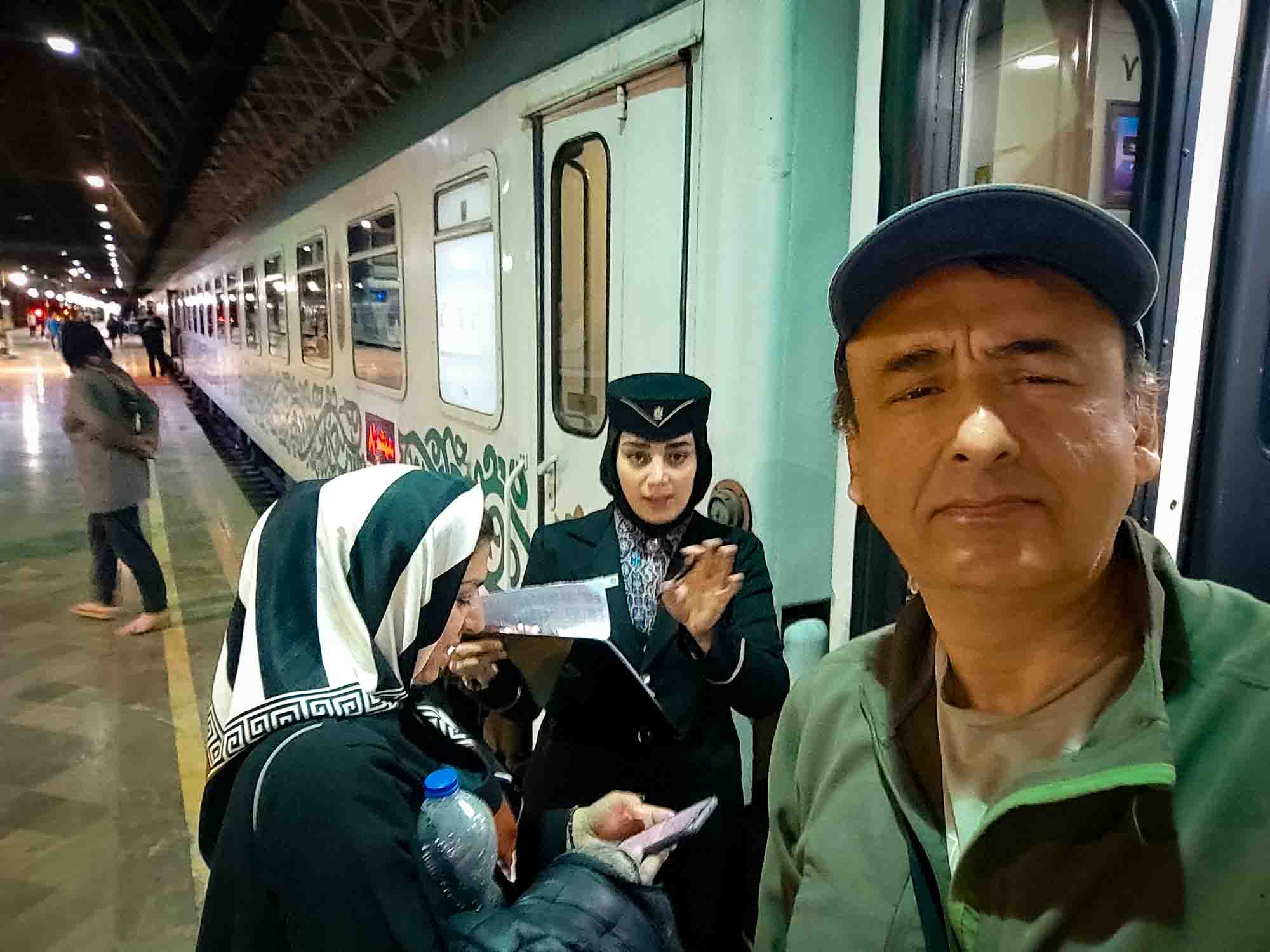 on our train trip in Iran Our Fadak train host helping us finding our sits at the Mashhad train station