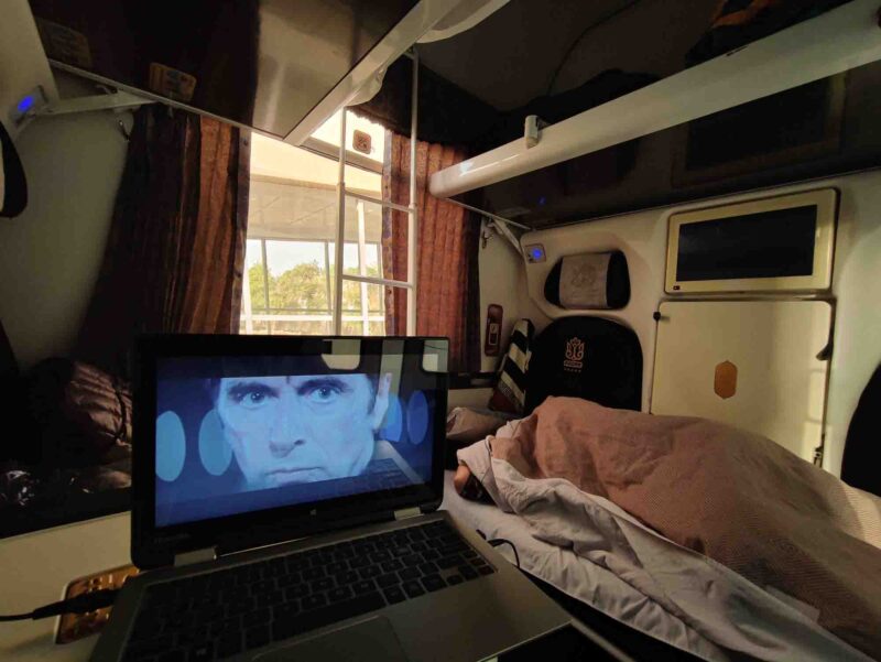Sleeping in our cabin while my friend watching the Heat movie on the Iranian train Fadak luxury liner. Copyright © Ali Torkzadeh, EscapefromTehran.com